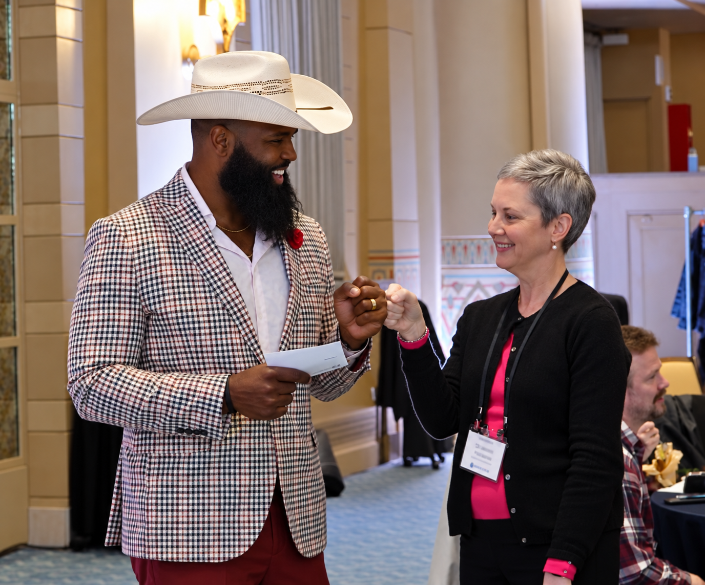 Andre Fluellen sharing a fist bump with an educator at a conference